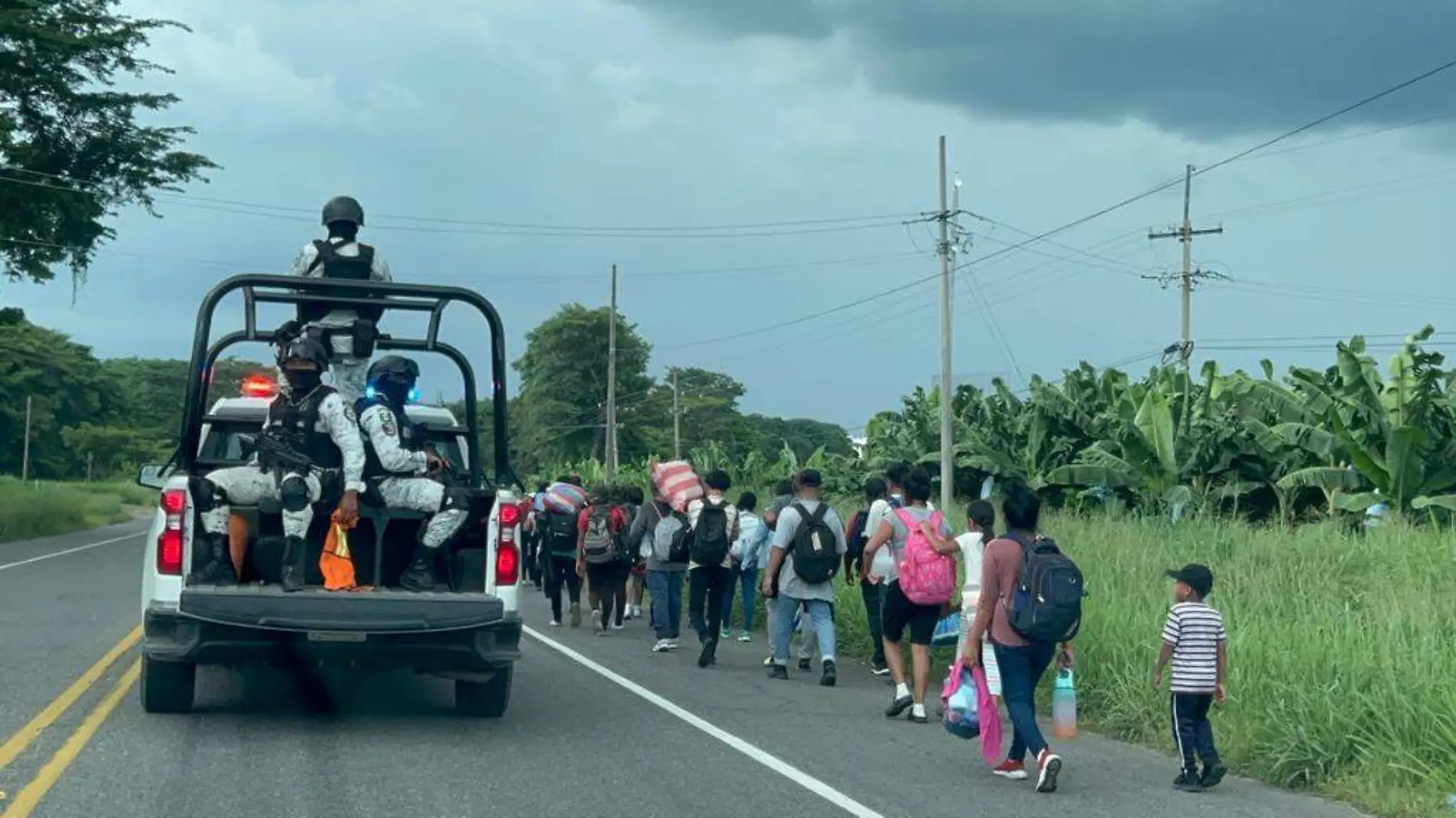 migrantes caminando por la carretera